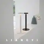 Modern rechargeable table lamp glowing warmly on a wooden bedside table