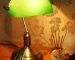 Antique bronze table lamp with green shade on bedside table