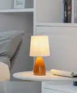 Milkshake bedside table lamp with warm LED light on a nightstand in a cozy bedroom