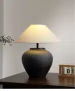 Wabi sabi table lamp with textured ceramic base and linen shade in a cozy living room
