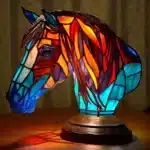 Colorful stained glass animal lamp featuring a cat design, glowing warmly on a bedside table
