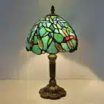 Vintage table lamp with handmade colored glass shade casting warm ambient light