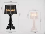 White ghost table lamp with transparent baroque design on a bedside table in a modern bedroom