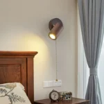 Walnut bedside wall light with adjustable spotlight and zipper switch in a cozy bedroom