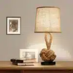 Vintage table lamp with hemp rope and iron base, emitting warm light on a bedside table
