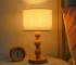 Vintage table lamp with fabric shade and solid wood base on bedside table