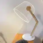 3D LED table lamp with wooden base and acrylic art glowing in a cozy room