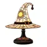 Witch hat lamp with stained glass pattern casting a warm glow on a bedside table