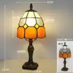 Tiffany table lamp with colorful stained glass shade casting warm glow on nightstand