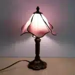 Vintage table lamp with handmade colored glass shade casting warm ambient light
