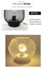Decorative bird cage lamp with warm LED light, iron frame, and silk screen details on a bedside table