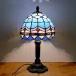 Vintage table lamp with handmade colored glass shade casting warm ambient light