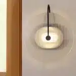 Modern wall lamp with minimalist Nordic design illuminating a cozy bedroom bedside
