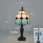 Tiffany table lamp with colorful stained glass shade casting warm glow on nightstand