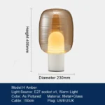 Modern table lamp with glass shade on bedside table