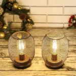 Battery table lamp with metal cage and warm LED glow on a wooden table
