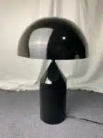 Modern mushroom table lamp with metal shade and wood base on bedside table