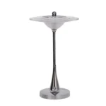 Goldoma rechargeable table lamp with flying saucer shape and warm glow on a bedside table