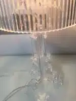 Modern acrylic table lamp glowing softly on a bedside table in a contemporary bedroom