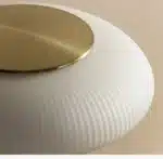 White glass table lamp with vintage design on a wooden desk in a cozy bedroom