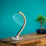 3D LED table lamp with wooden base and acrylic art glowing in a cozy room