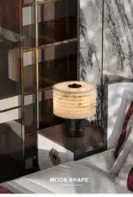 Elegant marble table lamp with soft glow on bedside table in bedroom