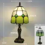 Tiffany table lamp with colorful stained glass shade casting warm glow on nightstand