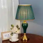 Green ceramic table lamp with European cloth shade in a modern living room setting
