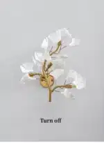 Luxury gold leaf sconce with modern ginkgo design illuminating a living room wall