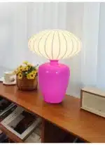 Vintage table lamp with retro ceramic base and silk shade on bedside table in cozy bedroom