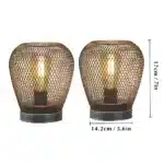Battery table lamp with metal cage and warm LED glow on a wooden table