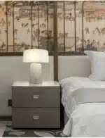 Elegant marble table lamp with soft glow on bedside table in bedroom