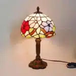 Vintage table lamp with handmade colored glass shade casting warm ambient light