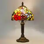 Vintage table lamp with handmade colored glass shade casting warm ambient light