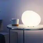 Modern table lamp with warm glow on bedside table