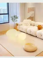 Warm night light pebble LED lamp glowing on a bedside table
