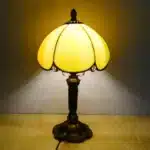 Vintage table lamp with handmade colored glass shade casting warm ambient light