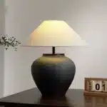 Wabi sabi table lamp with textured ceramic base and linen shade in a cozy living room