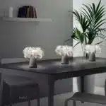Modern table lamp with PVC flower design in a cozy bedroom setting