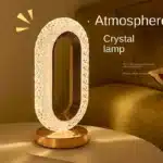 Elegant oval crystal table lamp with USB charging on a bedside table