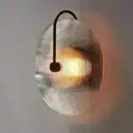 Modern wall lamp with minimalist Nordic design illuminating a cozy bedroom bedside
