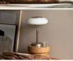 White glass table lamp with vintage design on a wooden desk in a cozy bedroom