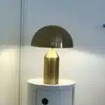 Modern mushroom table lamp with metal shade and wood base on bedside table