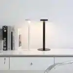 Modern rechargeable table lamp glowing warmly on a wooden bedside table
