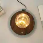 Floating LED lamp with levitating bulb on a wooden desk in a modern living room