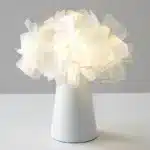 Modern table lamp with PVC flower design in a cozy bedroom setting