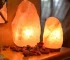 Salt lamp with color changing on wooden base glowing in warm light