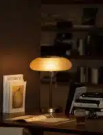 White glass table lamp with vintage design on a wooden desk in a cozy bedroom