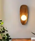 Vintage wall sconce with wooden backplate and clear glass shade, warm light