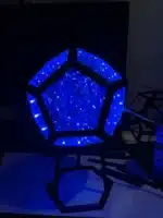 Dodecahedron gaming light with vibrant RGBW colors illuminating a gaming desk setup